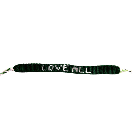A dark green beaded bracelet with white beads spelling out 'LOVE ALL' on a plain white background.